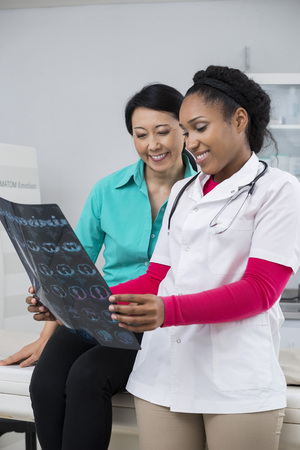 Woman And Doctor Looking At Chest X-ray In Examination Roomの写真素材