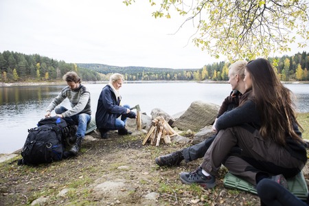 Friends Preparing For Camping On Lakeshoreの写真素材