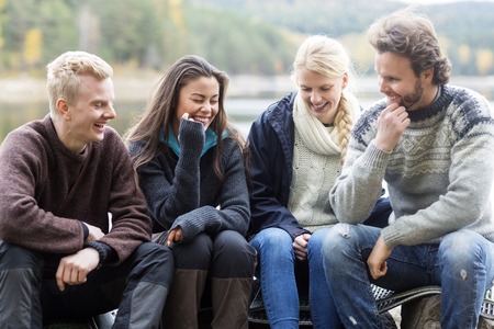 Smiling Friends Enjoying Camping On Lakeshoreの写真素材