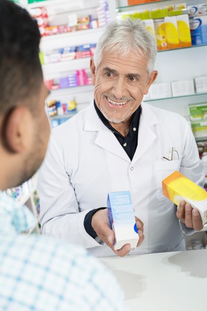 Senior Chemist Holding Products While Looking At Customerの写真素材