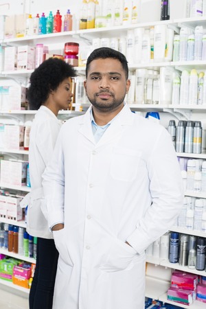 Chemist Standing With Hands In Pockets By Colleagueの写真素材