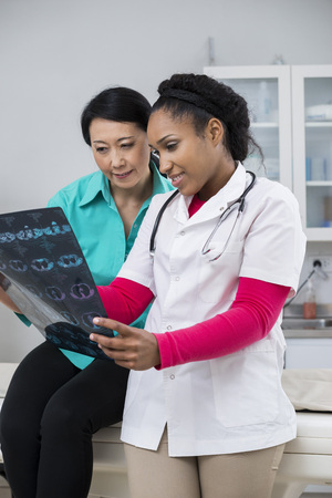 Female Medical Professional Showing Chest X-ray Report To Patienの写真素材