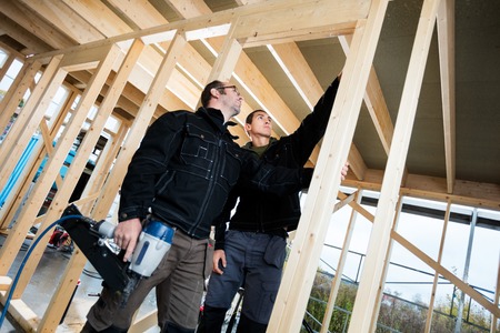 Professional Carpenters Analyzing Wood At Siteの写真素材