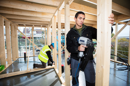 Carpenters Drilling Wood At Construction Siteの写真素材