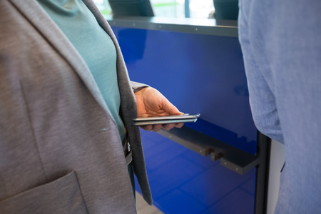 Businesswoman Holding Mobile Phone And Passport At Airport Recep
