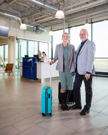 Senior Business Couple Standing While Receptionists Working In Aの写真素材