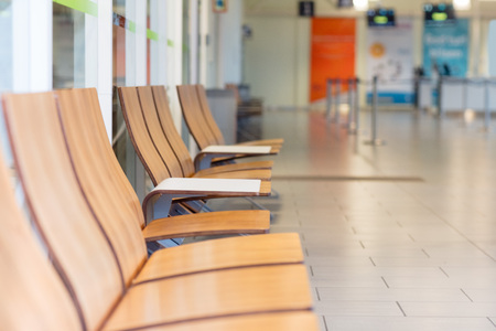 Row Of Wooden Chair In Waiting Room At Airport