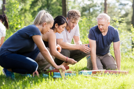 Friends Planning While Playing With Building Blocks On Grassy Fiの写真素材