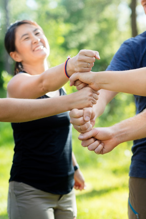Coworkers Stacking Fists In Forestの写真素材