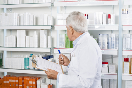Male Pharmacist Counting Stock In Pharmacyの写真素材