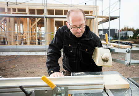 Carpenter Using Table Saw To Cut Plank At Siteの写真素材