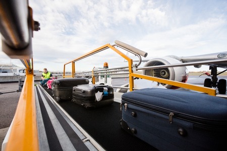 Baggage On Conveyor Belt Being Unloadedの写真素材