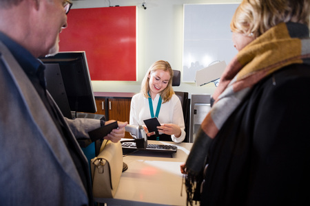 Staff Checking Passport Of Passengers At Airport Check-inの写真素材
