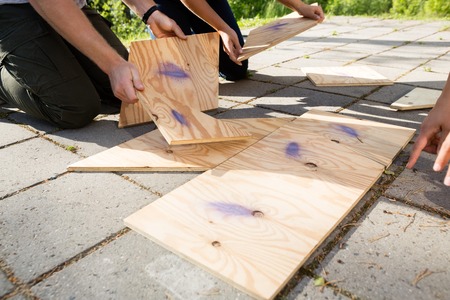 Cropped Image Of Friends Arranging Wooden Puzzle On Patioの写真素材