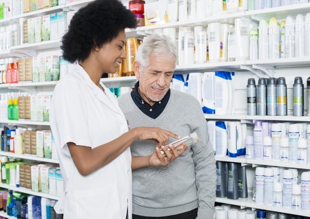 Pharmacist Showing Information On Product To Customerの写真素材