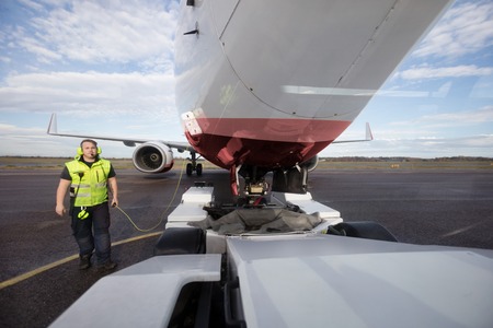 Ground Worker Standing By Aircraft With Communication Cable On Rの写真素材