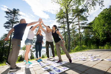 Friends Giving High-Five After Solving Crossword Puzzle On Patioの写真素材