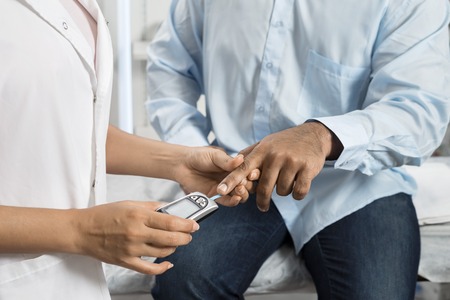 Female Doctor Examining Patients Sugar Level With Glucometerの写真素材