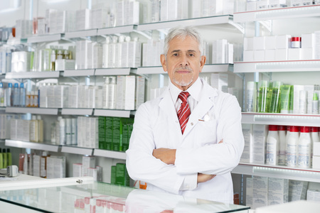 Pharmacist Standing Arms Crossed In Pharmacyの写真素材