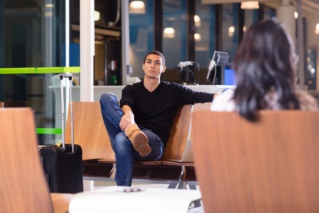 Man Sitting On Chair In Waiting Room At Airportの写真素材