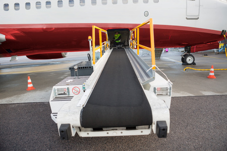 Conveyor Truck Attached To Airplane On Airport Runwayの写真素材