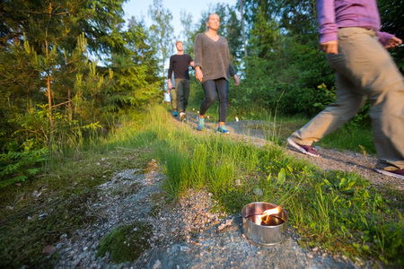 People Walking On Footpath By Lit Tealight Candle In Forestの写真素材