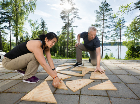Friends Solving Wooden Planks Puzzle On Patioの写真素材