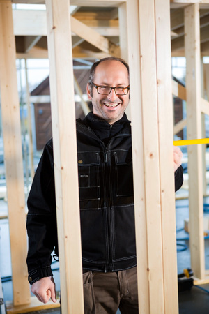 Happy Male Carpenter Working At Construction Siteの写真素材