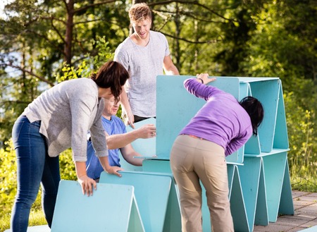 Friends Making Pyramid Of Planks On Patio In Forestの写真素材