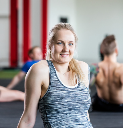 Woman Resting While Sitting On Floor In Gymの写真素材