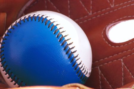 macro shot of a baseball inside a baseball gloveの写真素材