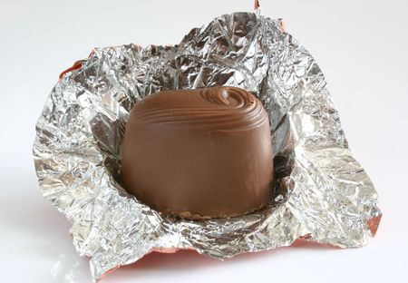unwrapped chocolate over a white backgroundの写真素材