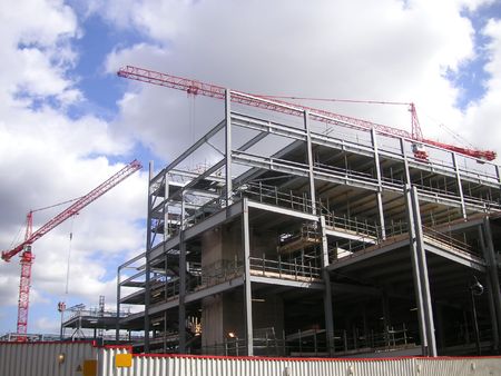 cranes above a building under constructionの写真素材