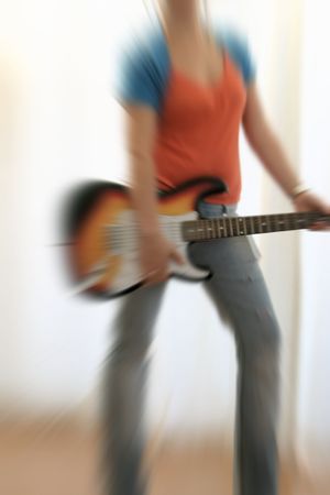 female guitarist playing electric guitar with radial blurrの写真素材