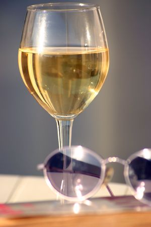 glass of wine with a sunglasses and a bookの写真素材