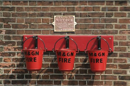 three fire buckets mounted on a wallの写真素材