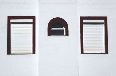 three windows on the wall of a buildingの写真素材