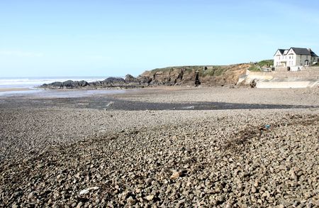 view across a stoney beach to overlooking residential buildingsの写真素材