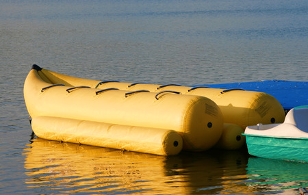 banana boat ride sitting on the water in the morning lightの写真素材