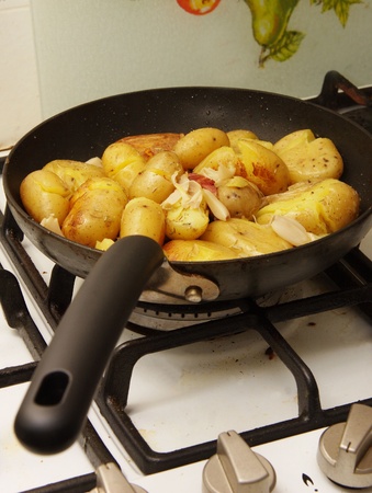 potatoes being fried in a panの写真素材
