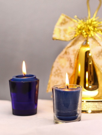 lit candles flickering around the decorative christmas bellの写真素材