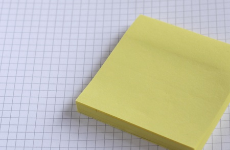 yellow notepad on a white squared sheet of paper