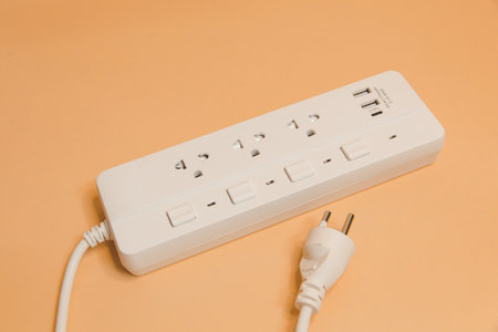 Electrical plug in outlet socket at home, Electrical plug in outlet socket at home, Energy efficiency concept, Power strip with extension cord on beige background, top view.の写真素材