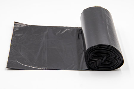 Black plastic garbage bags on white background, Roll of garbage bags on white backgroundの写真素材