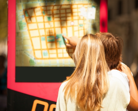 Woman and man watching a map on the street of an european cityの写真素材