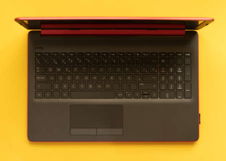 Laptop desk top view on yellow background. keyboard