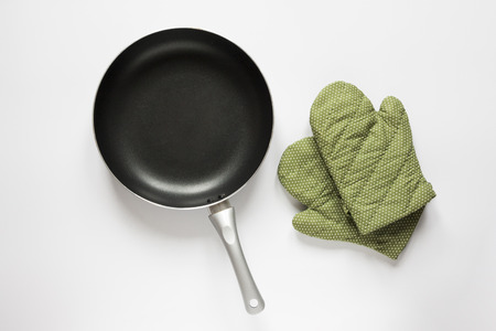 Top View a pan and green glove on white backgroundの写真素材