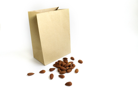 Almond pile beside brown paper bag photographed macro.の写真素材