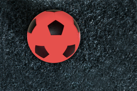 Red football on artificial grass, dark gray with clipping path. Have a blank space for text input.