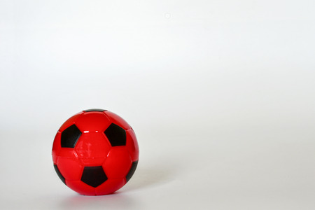 Red soccer ball alternating black on a white background.の写真素材